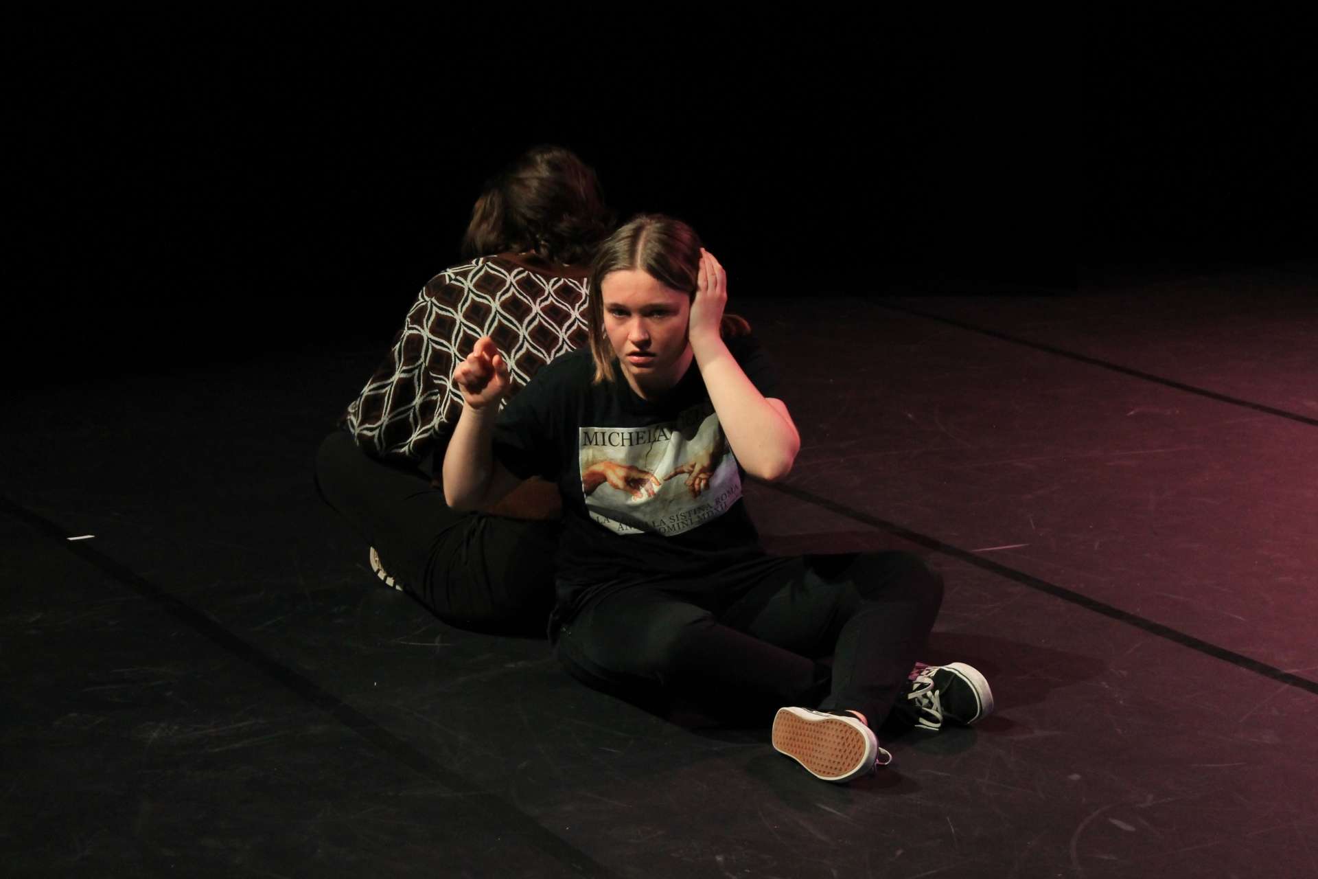 Deux étudiantes assies sur la scène de La Pokop pendant la représentation de théâtre étudiant franco-allemand 2022