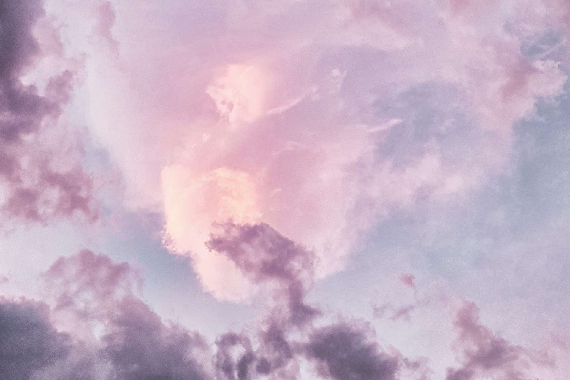 Image d'un ciel avec des nuages, le tout avec des teintes de rose et de violet