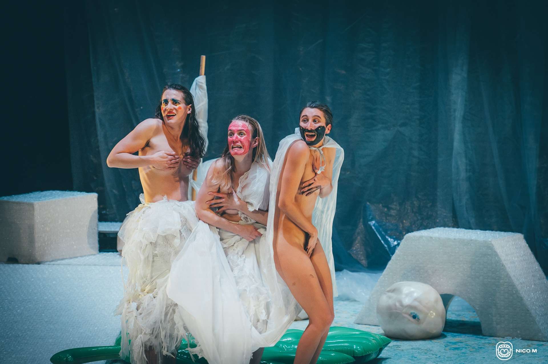 Photo du spectacle Sirènes : trois femmes sont sur scène. Deux femmes ont la poitrine dénudée, la troisième femme est nue. Toutes tentent de se cacher.