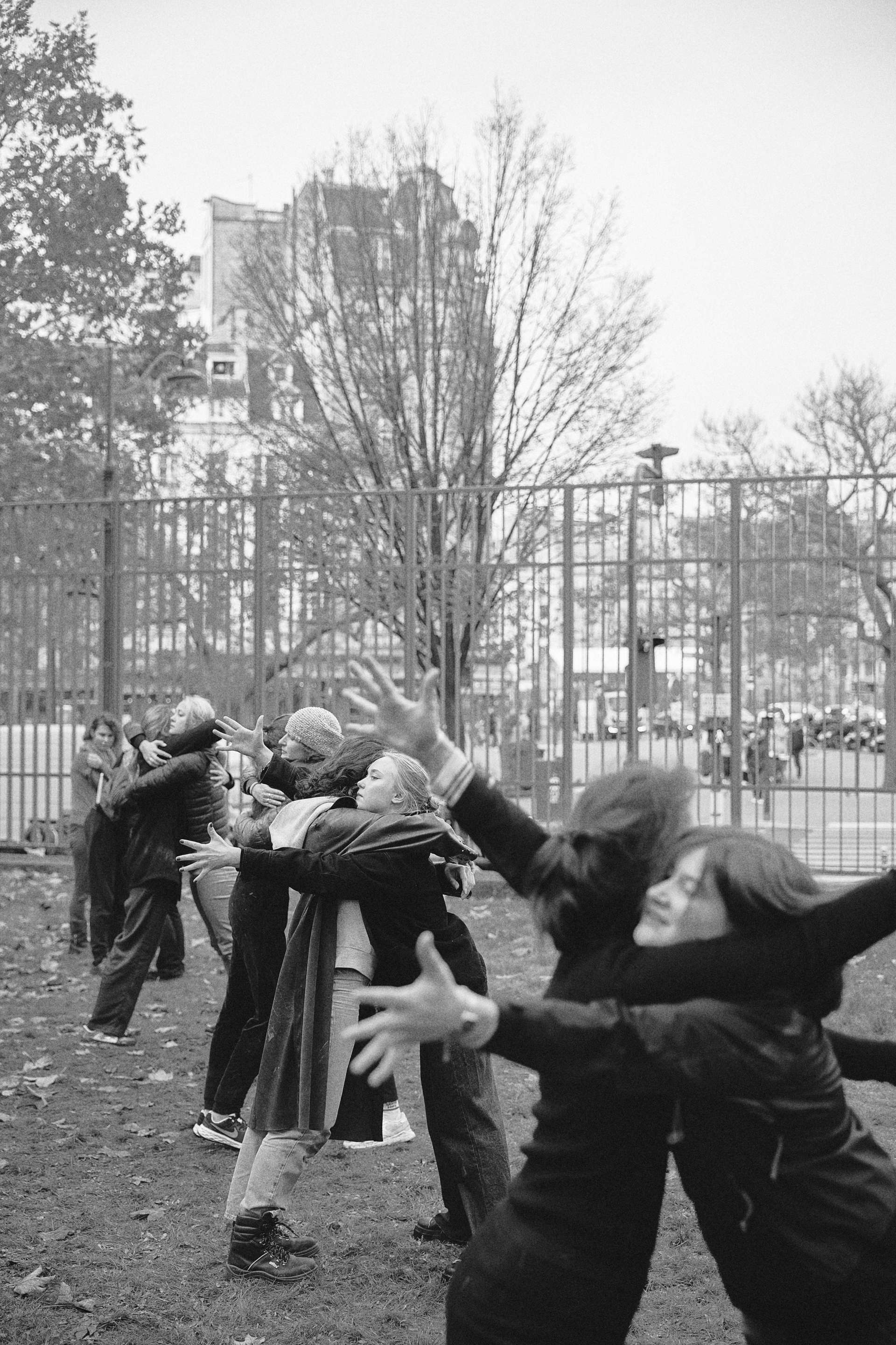 Photo noir et blanc, on y voit des enfants et adolescents qui se prennent dans les bras